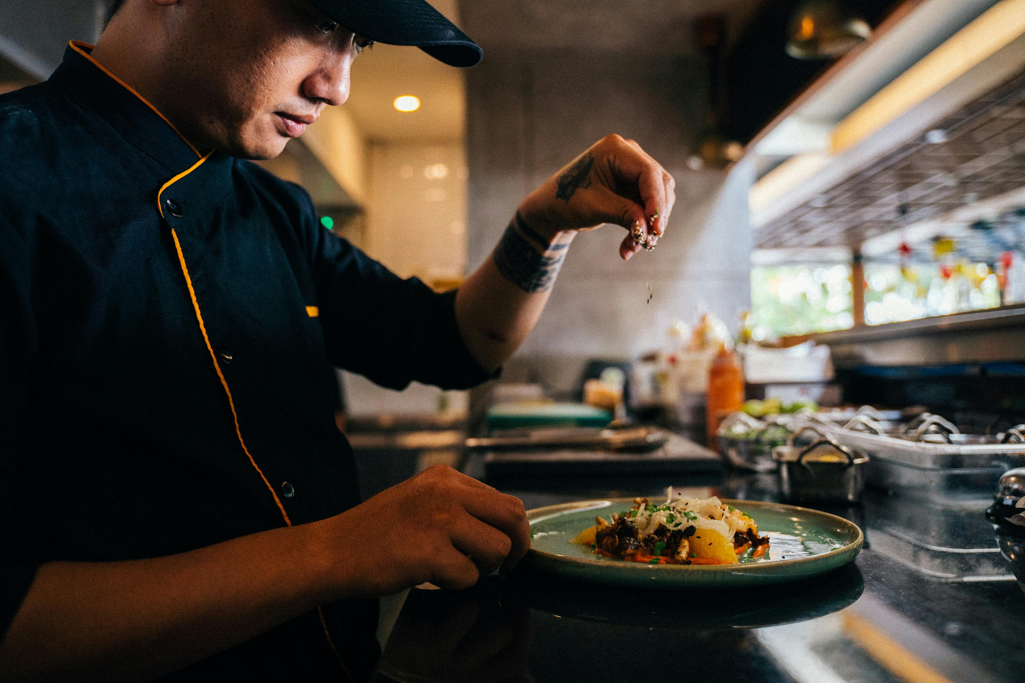 Chef finishing a plate in a professional kitchen